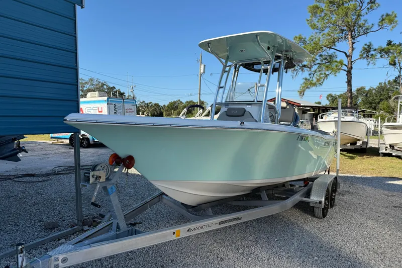 The Image of 2022 Key West 203 FS boat on trailer, parked outdoors near blue building. - 1