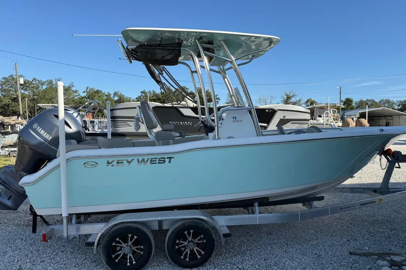 Slide: The Image of 2022 Key West 203 FS boat on trailer, featuring Yamaha engine, parked outdoors. - 2