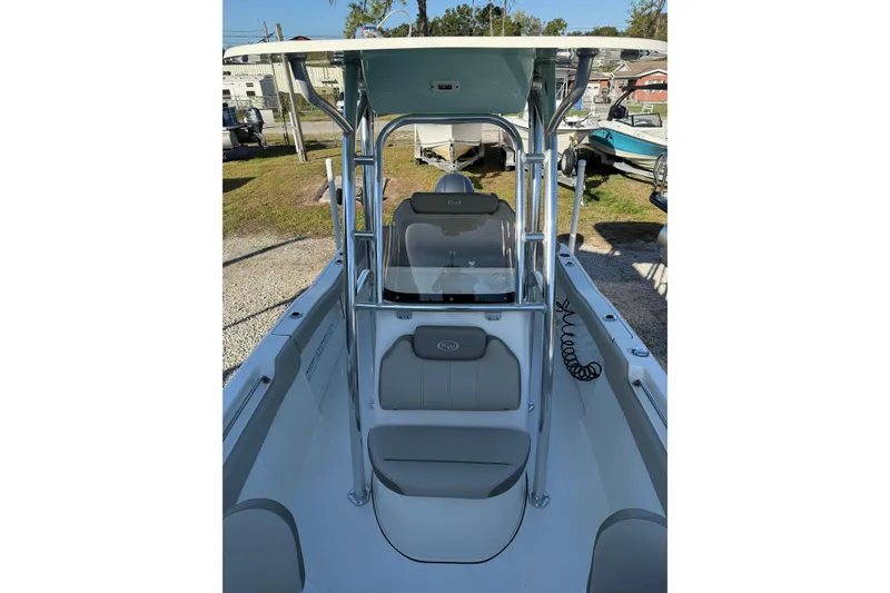 Slide: The Image of 2022 Key West 203 FS boat interior with seating and console, parked outdoors. - 6