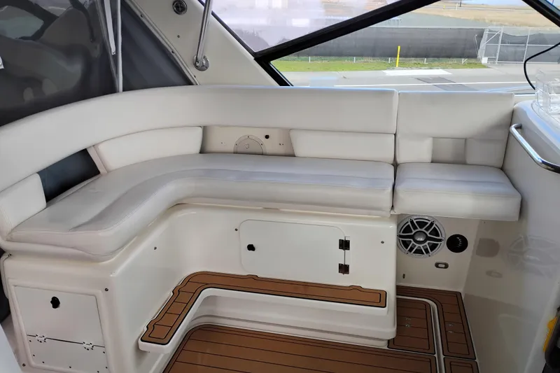 Slide: The Image of 1997 Tiara 3700 Open boat interior with white seating and wood-patterned flooring. - 16