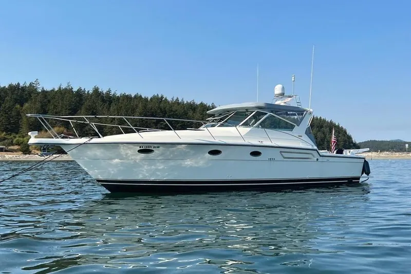 Slide: The Image of 1997 Tiara Yachts 3700 Open on calm water, forested shoreline in background. - 2