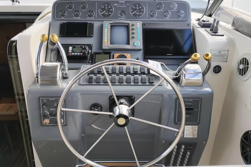 Slide: The Image of Control panel of a 1997 Tiara 3700 Open boat with steering wheel and navigation instruments. - 21
