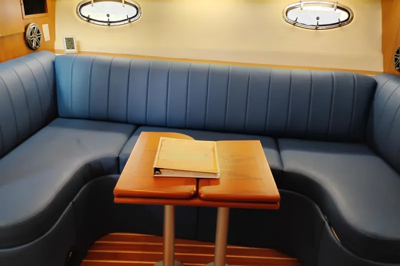 Slide: The Image of 1997 Tiara 3700 Open yacht interior with blue seating and wooden table. - 31