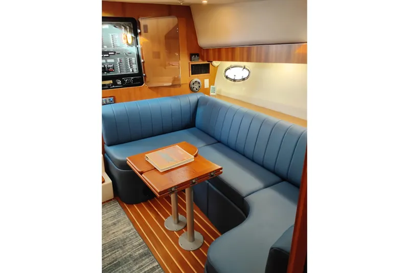 Slide: The Image of Interior of 1997 Tiara 3700 Open yacht with blue seating and wooden table. - 32