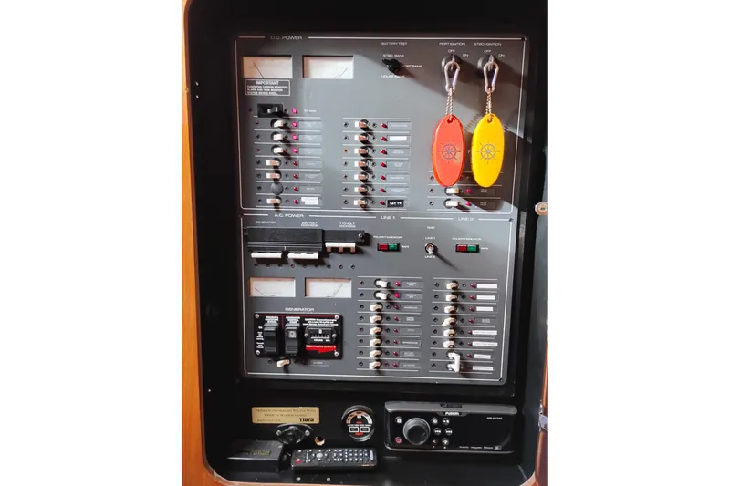 Slide: The Image of Electrical control panel of a 1997 Tiara 3700 Open boat with labeled switches and keychains. - 35