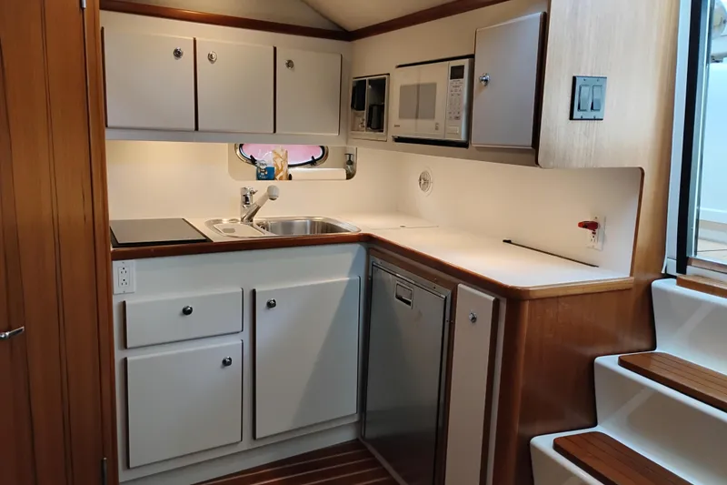 Slide: The Image of 1997 Tiara 3700 Open yacht kitchen with modern appliances and wooden cabinetry. - 36