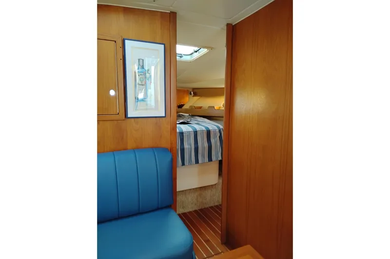 Slide: The Image of Interior of 1997 Tiara 3700 Open yacht with blue seating and striped bedding. - 43