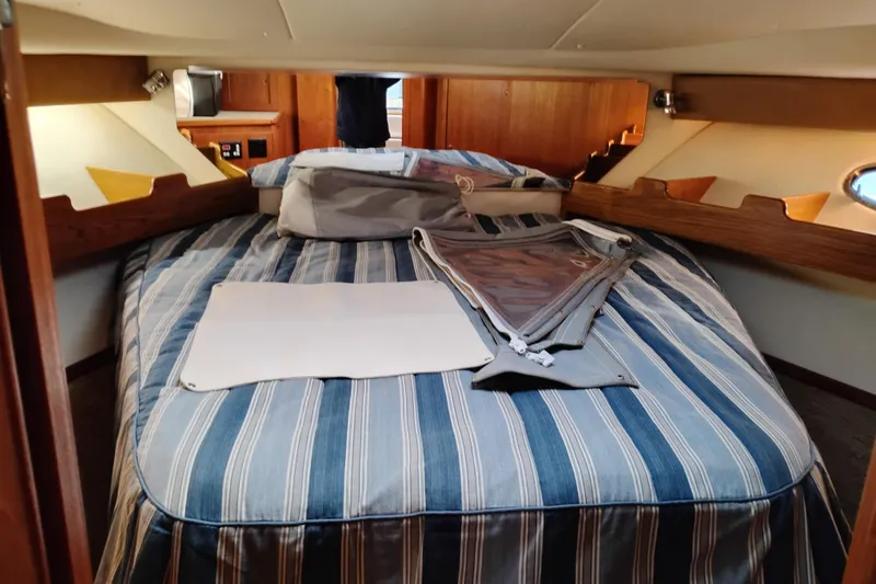 Slide: The Image of Interior cabin of 1997 Tiara 3700 Open yacht with striped bedding and wooden accents. - 45