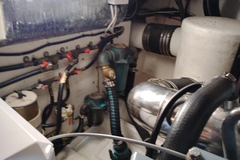 Slide: The Image of Engine room of a 1997 Tiara 3700 Open boat, showcasing mechanical components and hoses. - 57