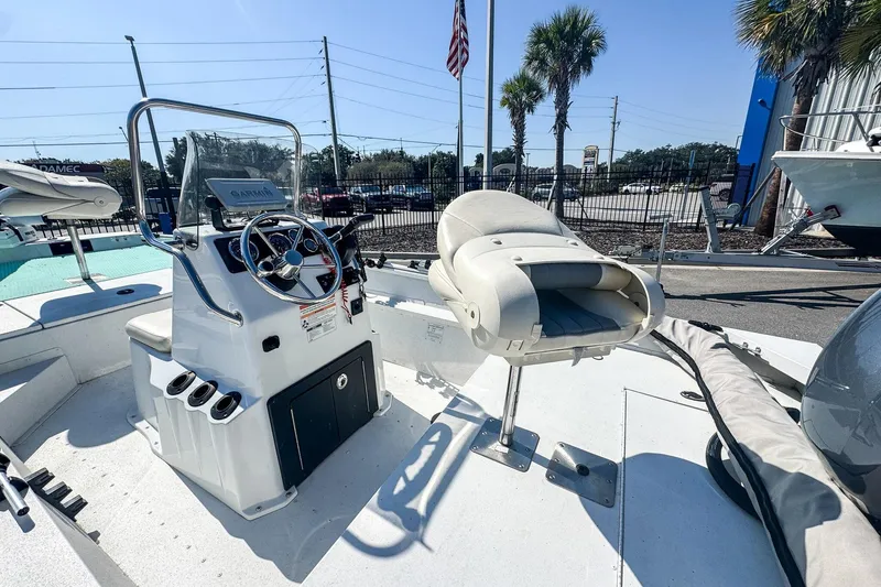 Slide: The Image of 2023 G3 Bay 17 boat interior with steering console and seating, parked outdoors. - 4