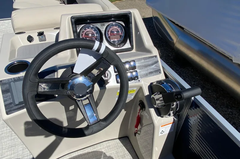 Slide: The Image of 2023 Harris Cruiser 250 boat dashboard with steering wheel and controls. - 6
