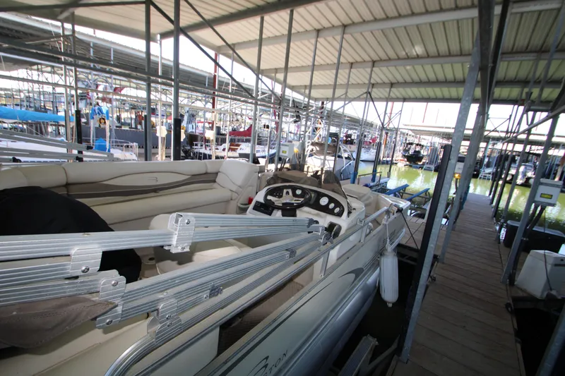 Slide: The Image of 2005 Bennington 2275FSi pontoon boat docked in a covered marina. - 13