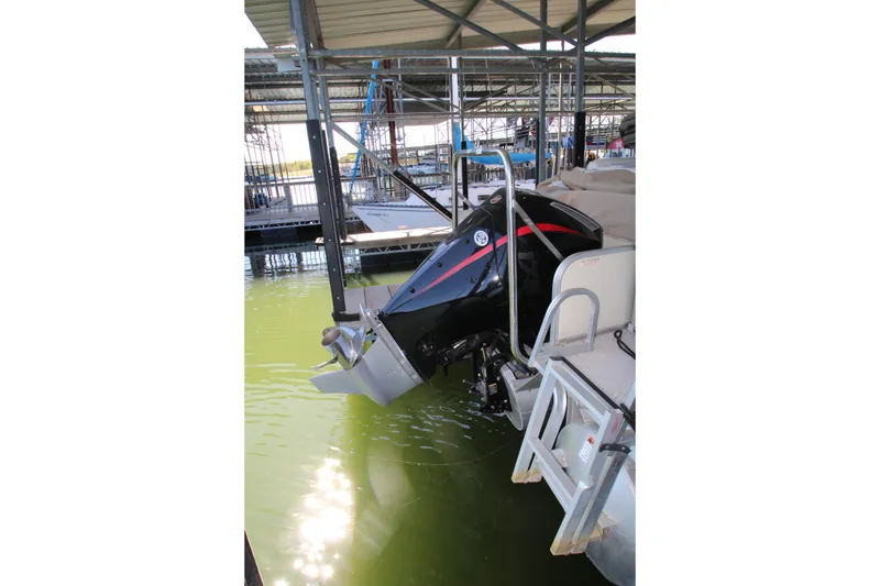 Slide: The Image of 2005 Bennington 2275FSi pontoon boat docked with visible outboard motor. - 18