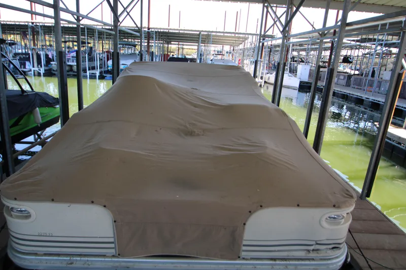 Slide: The Image of 2005 Bennington 2275FSi pontoon boat docked under a covered marina. - 5