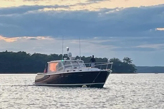 Slide: The Image of 2013 MJM 40z Express boat on calm water at sunset. - 2