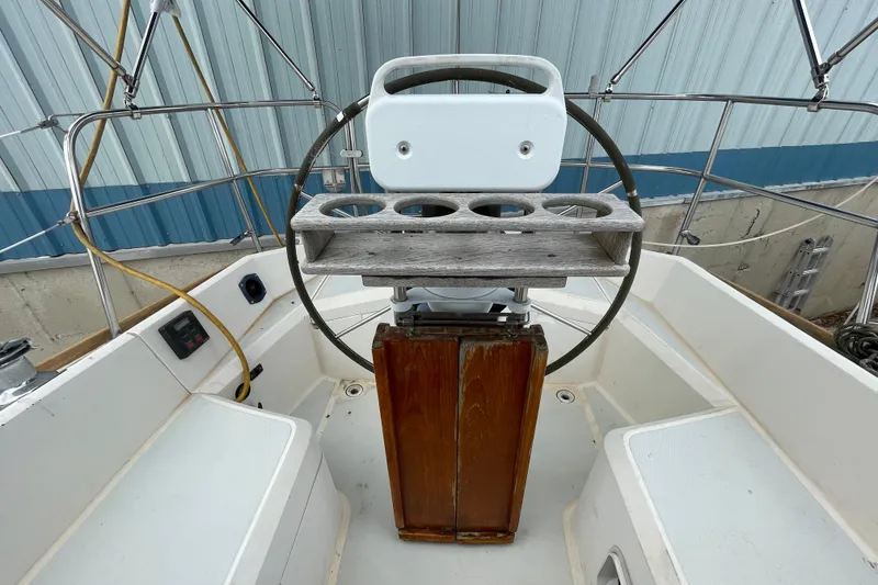 Slide: The Image of Cockpit of 1988 CAL 28 sailboat with steering wheel and wooden console. - 10