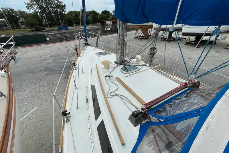 Slide: The Image of Sailboat CAL 28, 1988 model, docked with blue canopy and visible rigging. - 14