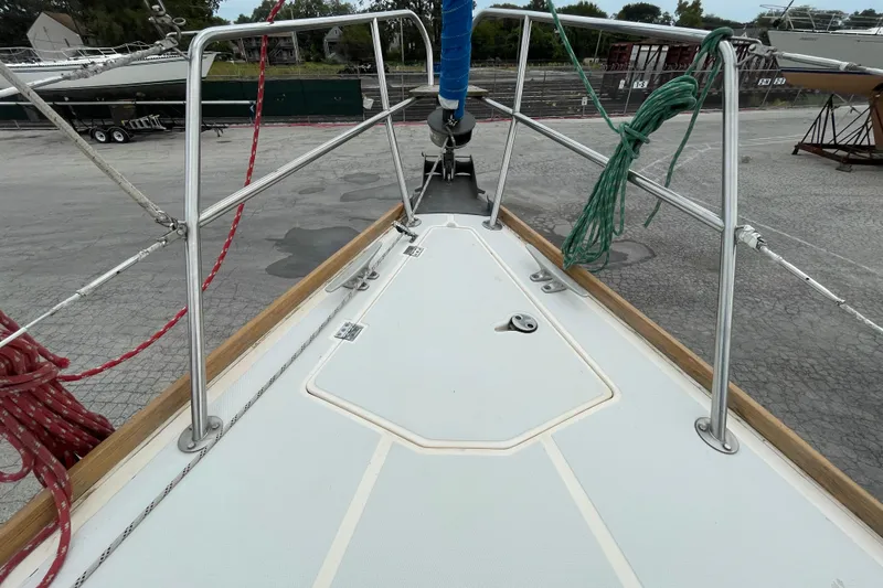 Slide: The Image of Bow of 1988 CAL 28 sailboat with ropes and railing in a marina setting. - 15