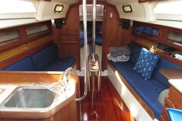 Slide: The Image of Interior of 1988 CAL 28 sailboat with wooden finish and blue seating. - 23