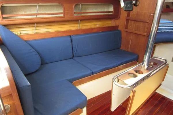 Slide: The Image of Interior of 1988 CAL 28 sailboat with blue cushioned seating and wooden accents. - 24