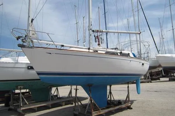 Slide: The Image of 1988 CAL 28 sailboat on stands, white hull with blue keel, docked in a marina. - 3