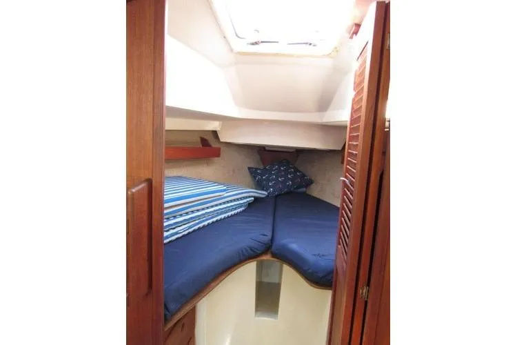Slide: The Image of Cozy cabin interior of 1988 CAL 28 sailboat with blue bedding and wooden accents. - 37