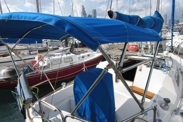 Slide: The Image of 1988 CAL 28 sailboat with blue canopy docked in marina, surrounded by other boats. - 7