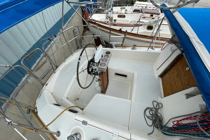 Slide: The Image of 1988 CAL 28 sailboat cockpit with steering wheel and blue canopy. - 8