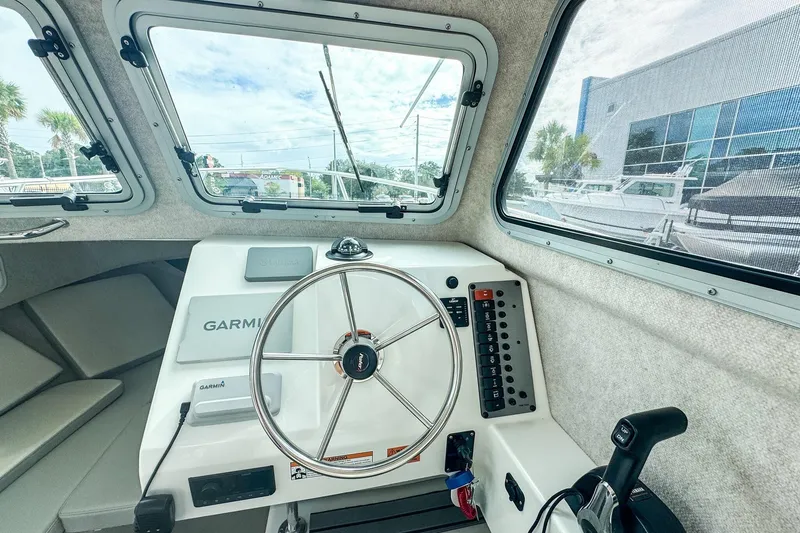 Slide: The Image of Interior view of 2023 Parker 2120 Sport Cabin boat with steering wheel and Garmin navigation system. - 10