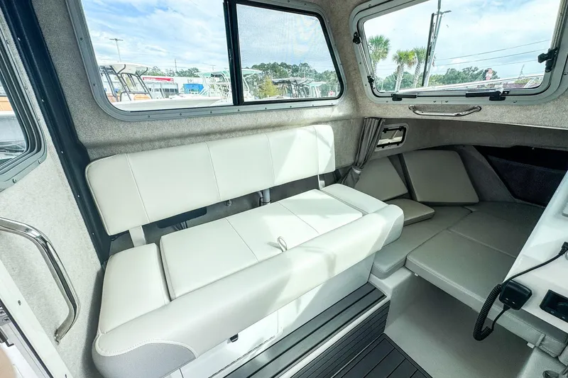 Slide: The Image of Interior of 2023 Parker 2120 Sport Cabin with white seating and large windows. - 11