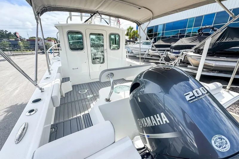 Slide: The Image of 2023 Parker 2120 Sport Cabin boat with Yamaha 200 engine, docked outdoors. - 4