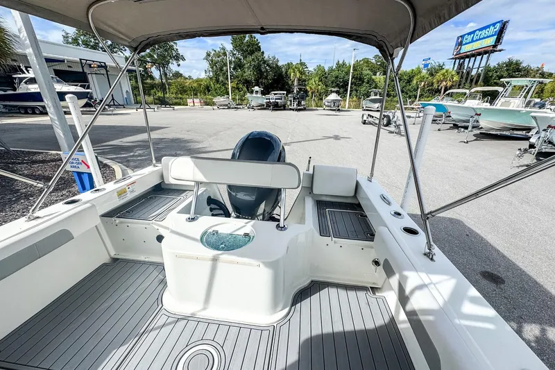 Slide: The Image of 2023 Parker 2120 Sport Cabin boat interior with seating and outboard motor. - 5