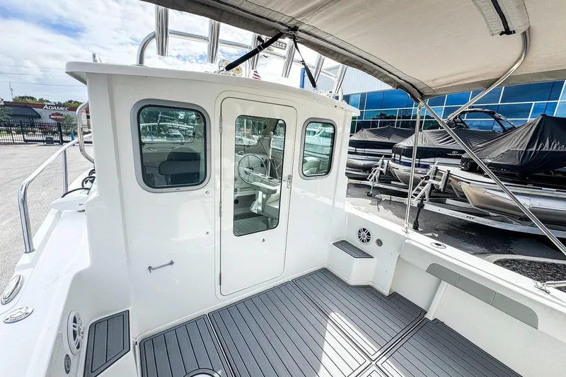 Slide: The Image of 2023 Parker 2120 Sport Cabin boat with sleek design and spacious deck area. - 6