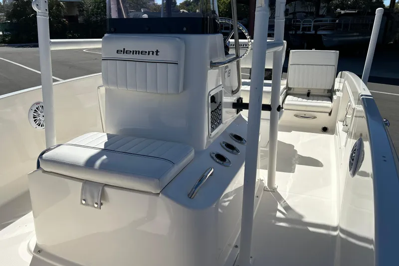 Slide: The Image of 2019 Bayliner Element F18 boat interior with white seating and steering console. - 10