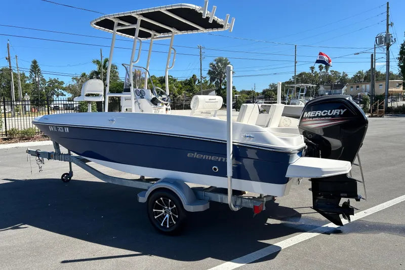 Slide: The Image of 2019 Bayliner Element F18 boat with Mercury outboard motor on a trailer in a parking lot. - 4