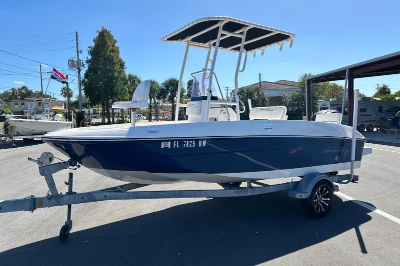 Slide: The Image of 2019 Bayliner Element F18 boat on trailer, parked outdoors under clear sky. - 5