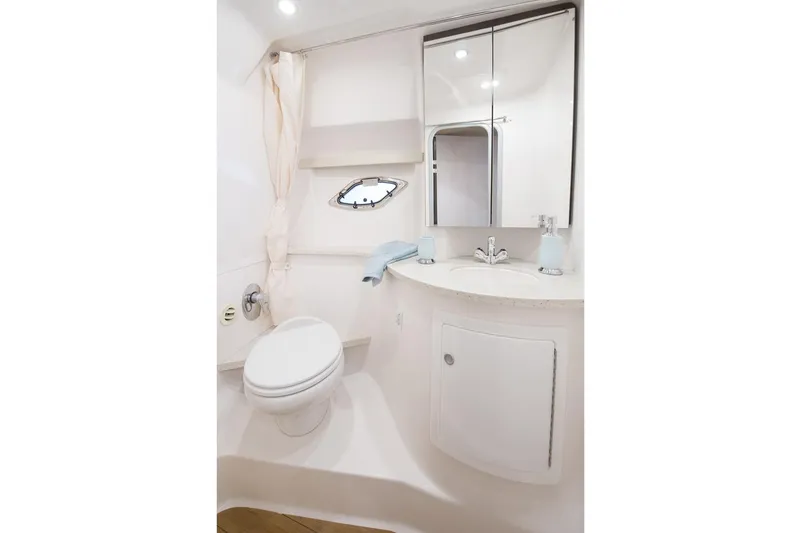 Slide: The Image of Manufacturer Provided Image: 2017 Regal 35 Sport Coupe bathroom with toilet, sink, mirror, and porthole. - 14
