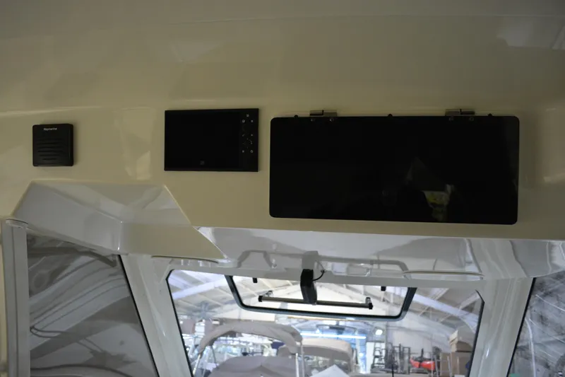 Slide: The Image of Interior view of 2019 Boston Whaler 350 Realm boat, featuring beige seating and stainless steel handle. - 39