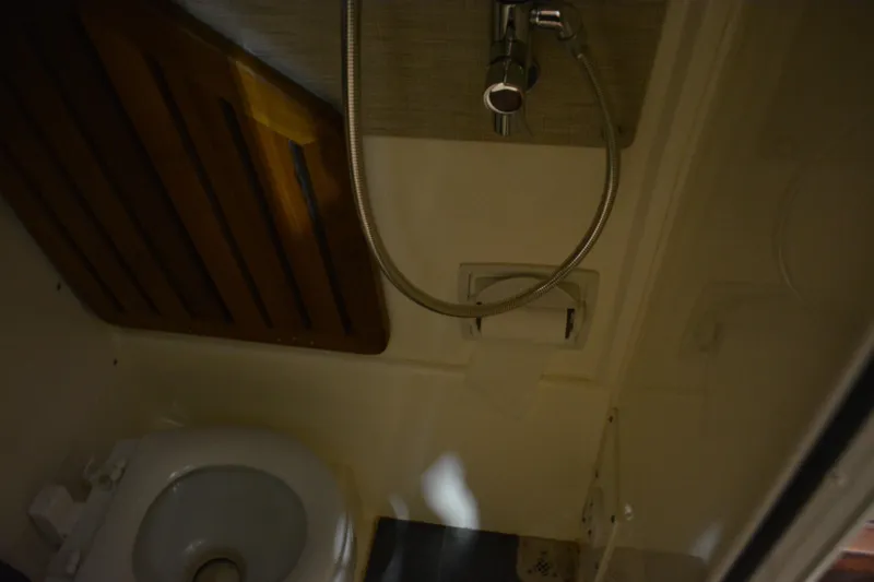 Slide: The Image of 2019 Boston Whaler 350 Realm interior storage with shelves and curtain. - 52