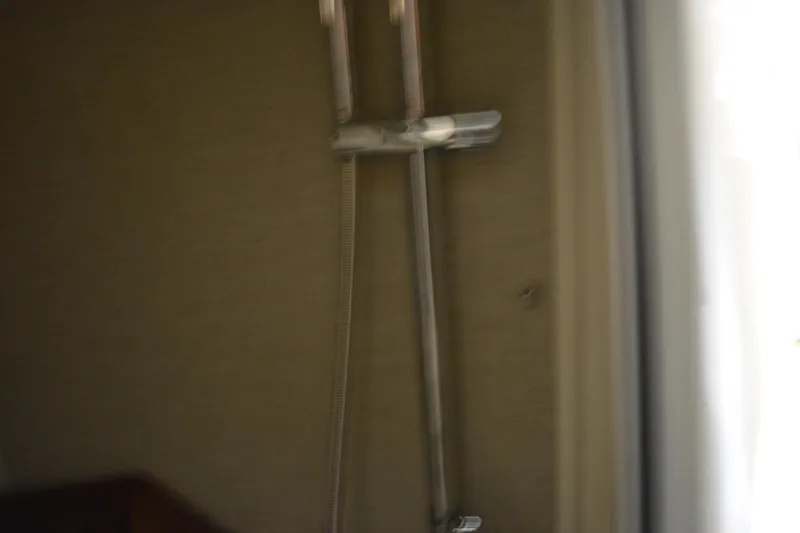 Slide: The Image of 2019 Boston Whaler 350 Realm bathroom with toilet and showerhead. - 53