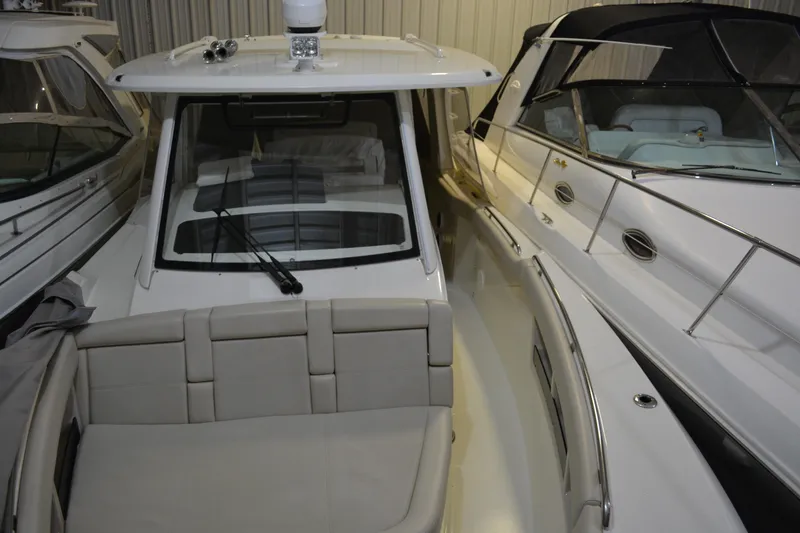 Slide: The Image of 2019 Boston Whaler 350 Realm boat docked indoors, showcasing sleek design and spacious seating. - 65