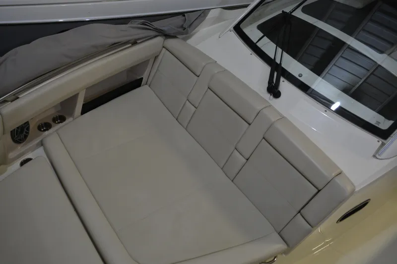 Slide: The Image of 2019 Boston Whaler 350 Realm interior seating with beige upholstery and cup holders. - 67