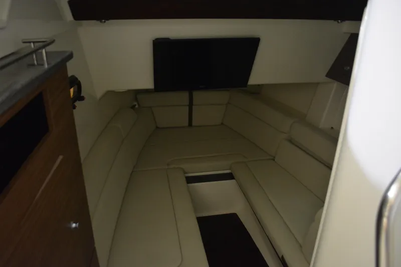 Slide: The Image of 2019 Boston Whaler 350 Realm cabin interior with beige seating and a mounted TV. - 84