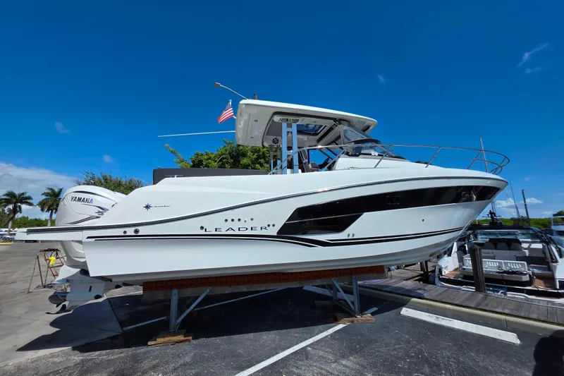 Slide: The Image of 2021 Jeanneau Leader 10.5 WA boat displayed outdoors under clear blue sky. - 1