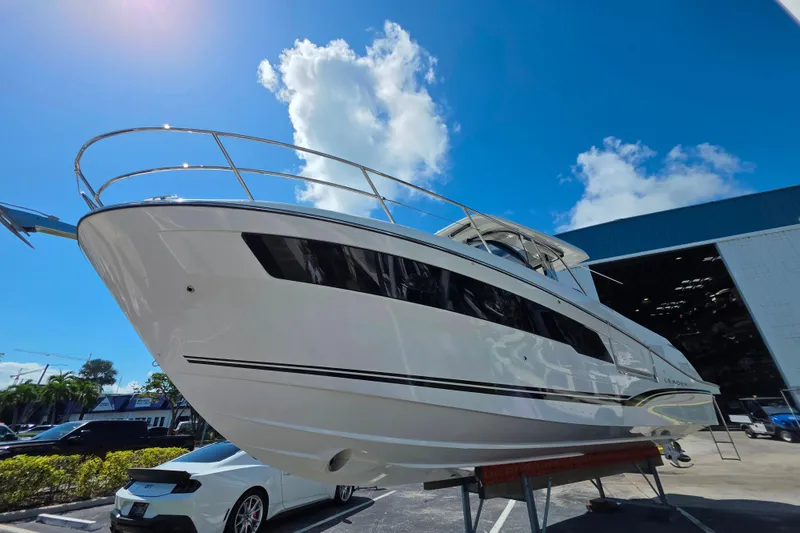 Slide: The Image of 2021 Jeanneau Leader 10.5 WA boat displayed outdoors under clear blue sky. - 10