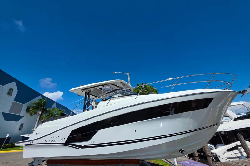 Slide: The Image of 2021 Jeanneau Leader 10.5 WA boat with seating and table, docked at a marina. - 12