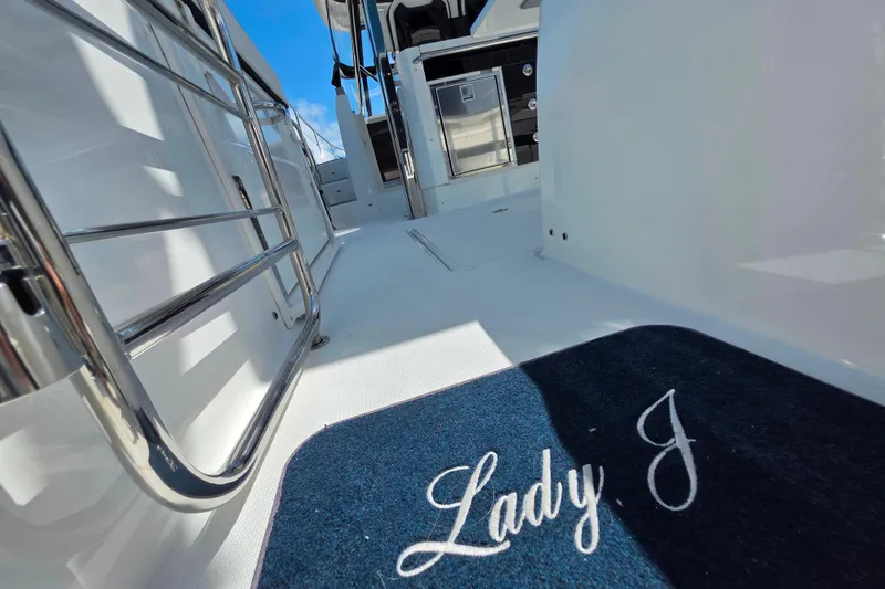 Slide: The Image of 2021 Jeanneau Leader 10.5 WA boat interior with seating and table, parked outdoors. - 17