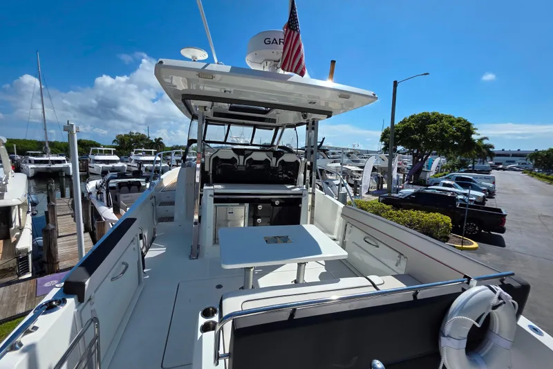 Slide: The Image of 2021 Jeanneau Leader 10.5 WA boat docked, featuring spacious deck and seating area. - 20