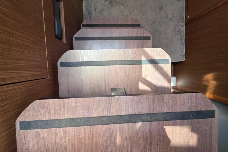 Slide: The Image of Interior of 2021 Jeanneau Leader 10.5 WA boat, featuring modern kitchen and wooden cabinetry. - 37