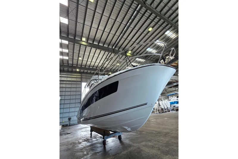 Slide: The Image of 2021 Jeanneau Leader 10.5 WA boat in a warehouse, viewed from the front. - 51